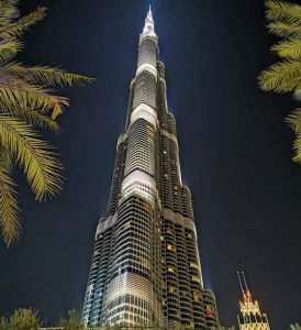 Burj Khalifa at night with palm trees 