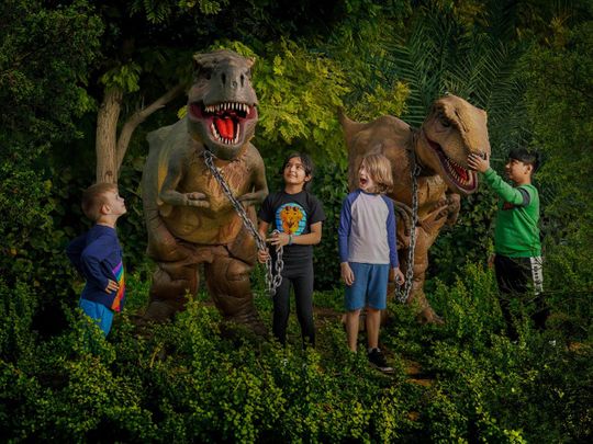 Children posing with the dinosaurs in the middle of the forest