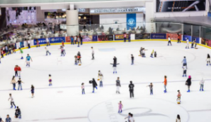 A bustling Dubai Ice Rink with numerous ice skaters enjoying the activity. 