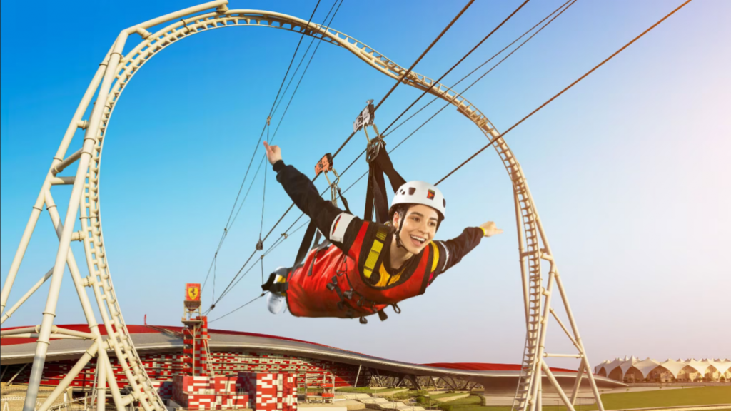 A woman soars through the air on the Ferrari World Zipline with her arms outstretched.