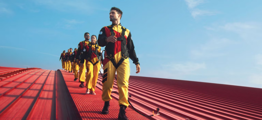 A group of thrill seekers walk on the Ferrari World's red roof.