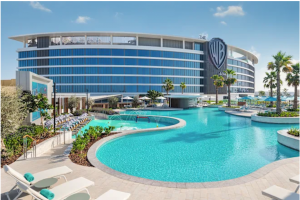 The WB Resort features a curved modern design with a large outdoor pool and palm trees.