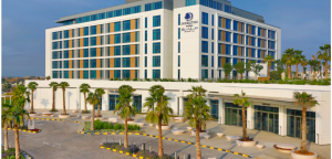 Exterior view of Double Tree Hotel featuring its upscale architectural structure with a hotel front surrounded by palm trees.