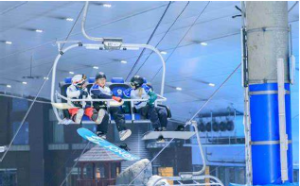 Three riders in full gear on a chairlift, elevated above the ski slopes. 