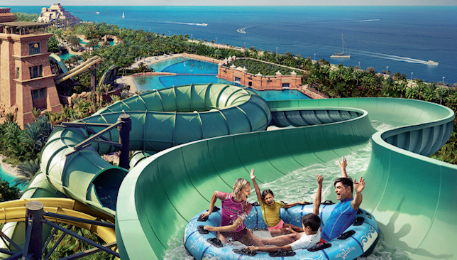 A family of four sliding down the winding course in an inflated tube