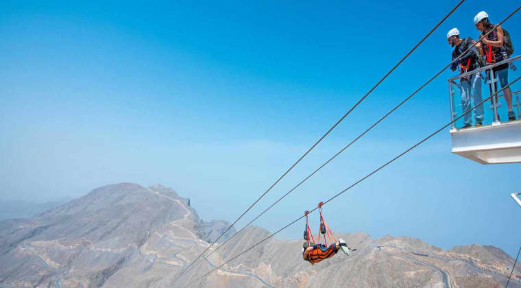 a man suspended in air on the zipline