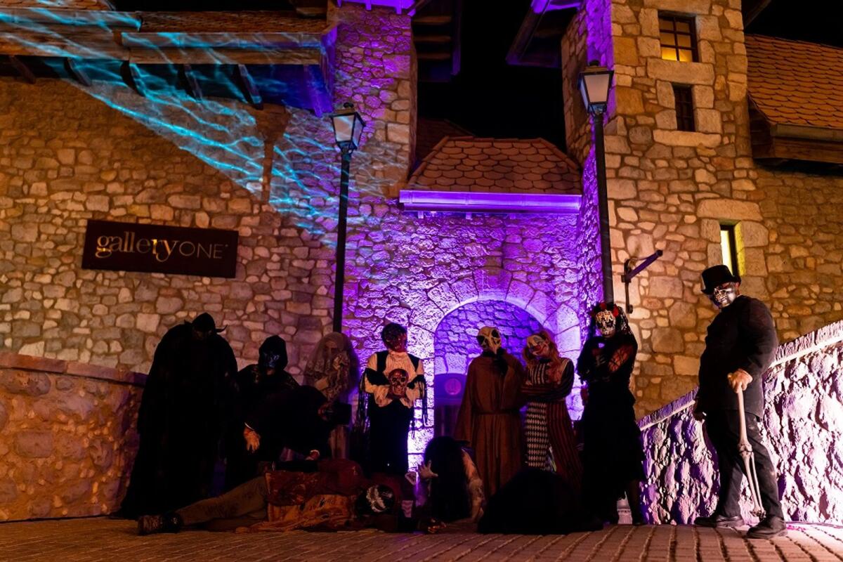 A group of people dressed in ghost costumes posing on the stone bridge