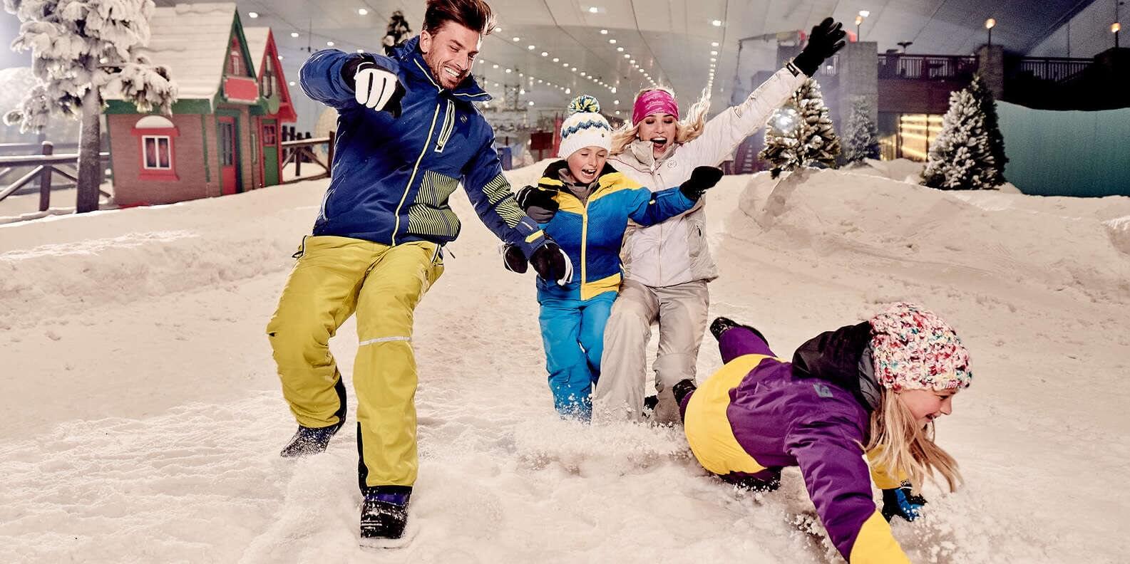 A family of four playing with the snow